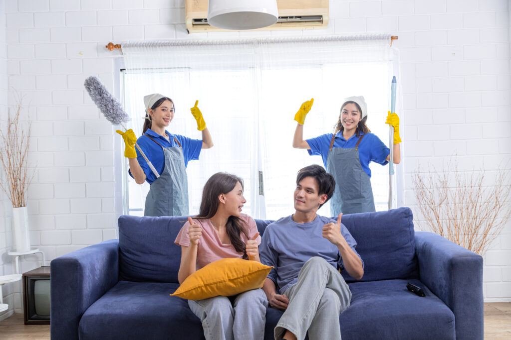 Asian newlywed business people decide to choose professional cleaning service teamwork to clean and tidy up new house both housekeeper team husband and wife happy sitting on sofa at home thumbs up | House Cleaning Rapid City South Dakota
